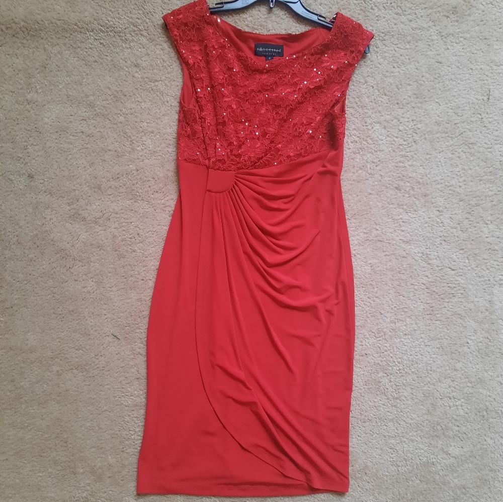 Red sleeveless dress has lace and sequence top. .